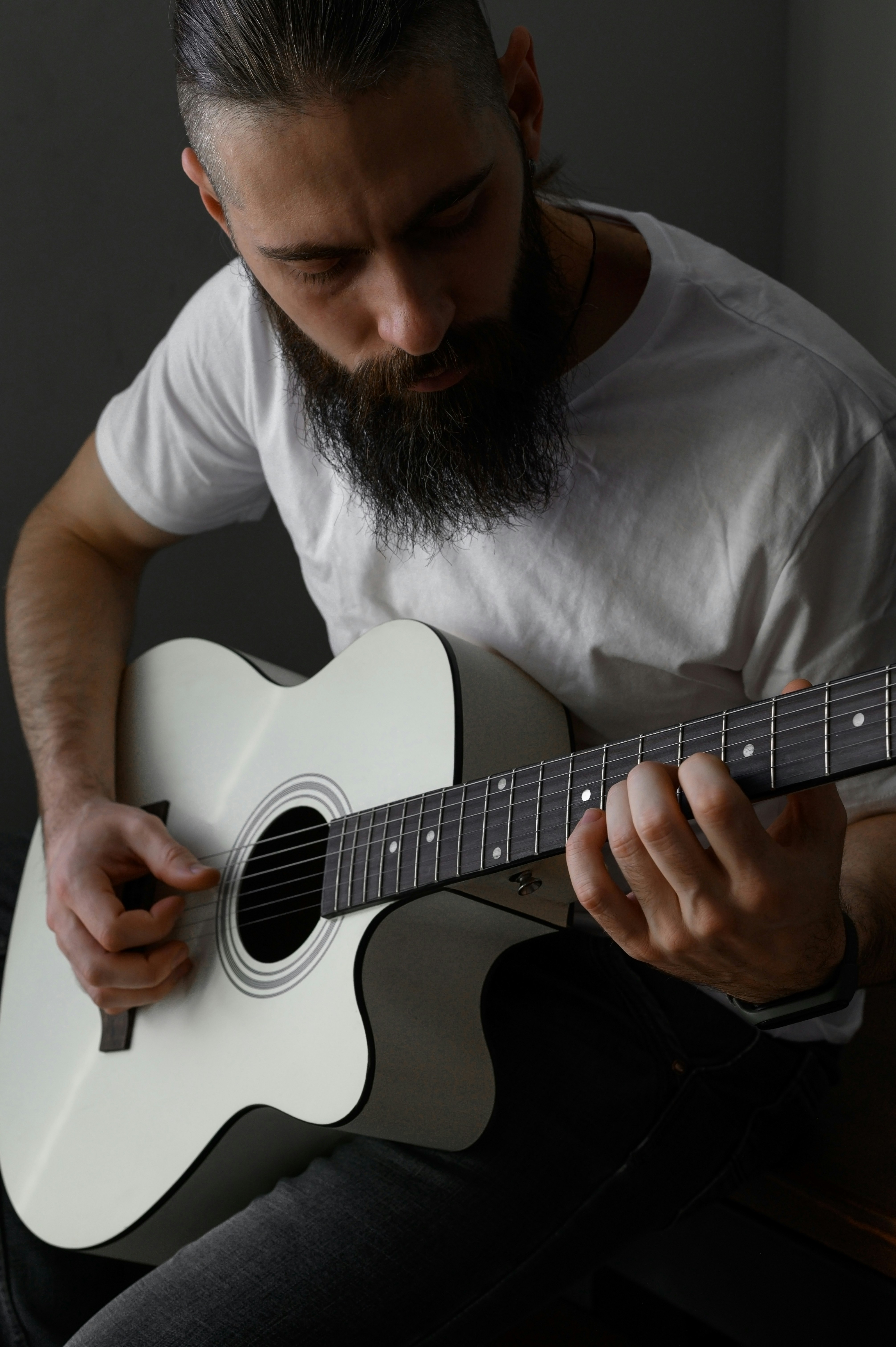 Un hombre con barba tocando una guitarra