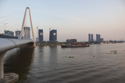 A modern bridge under construction spanning a river in a developing area.