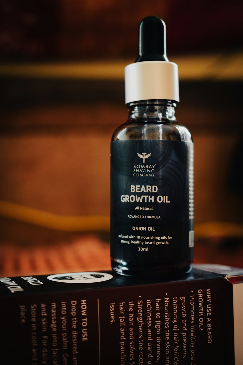 a bottle of beard growth oil sitting on top of a book