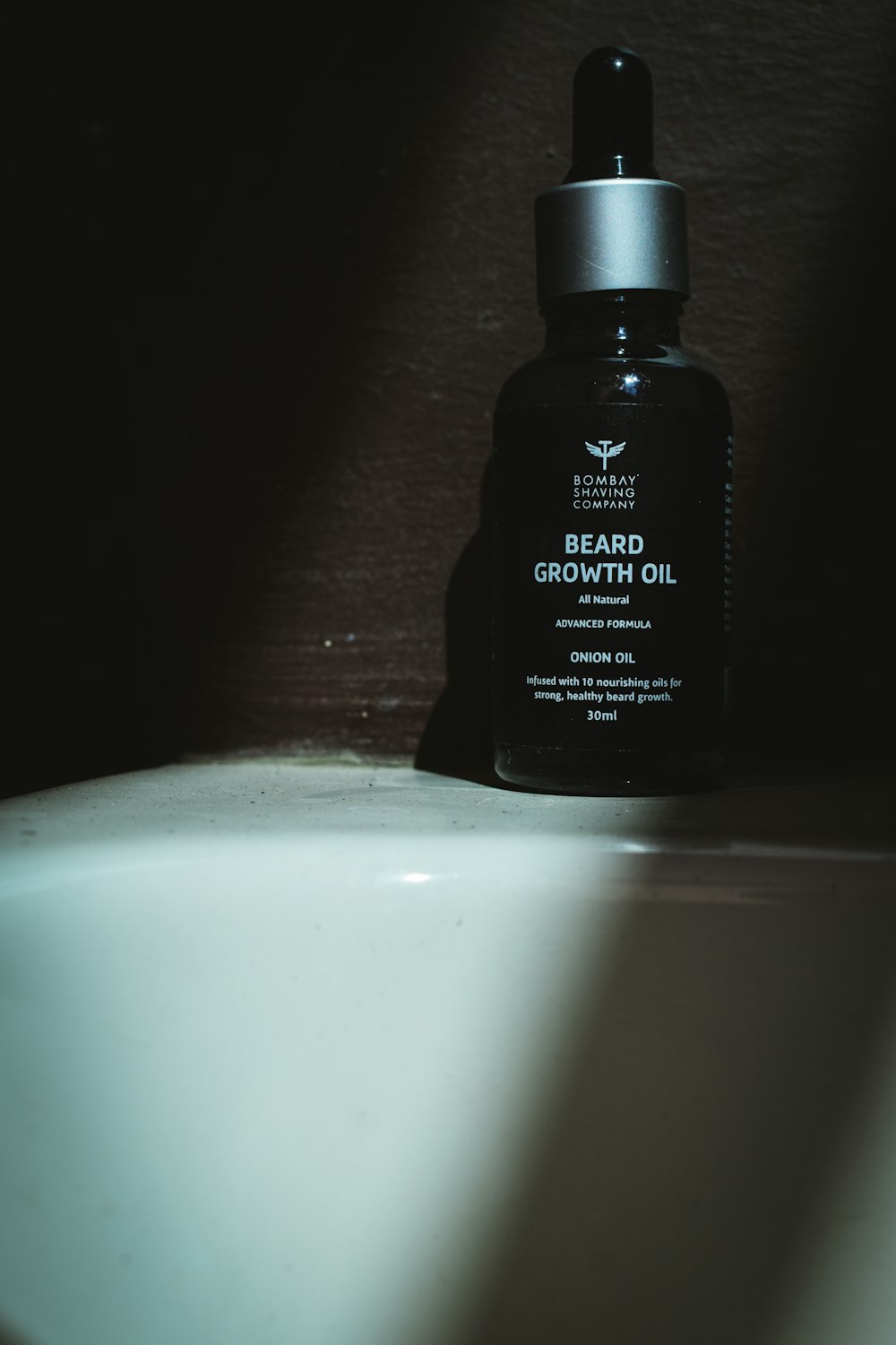 a bottle of beard growth oil sitting on a counter