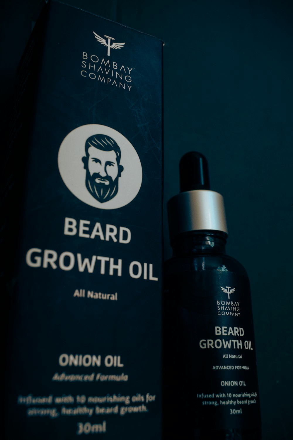 a bottle of beard growth oil next to a box