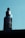 A bottle of beard growth oil with a dropper cap is set against a light blue background. The label on the bottle prominently displays the brand and product information.