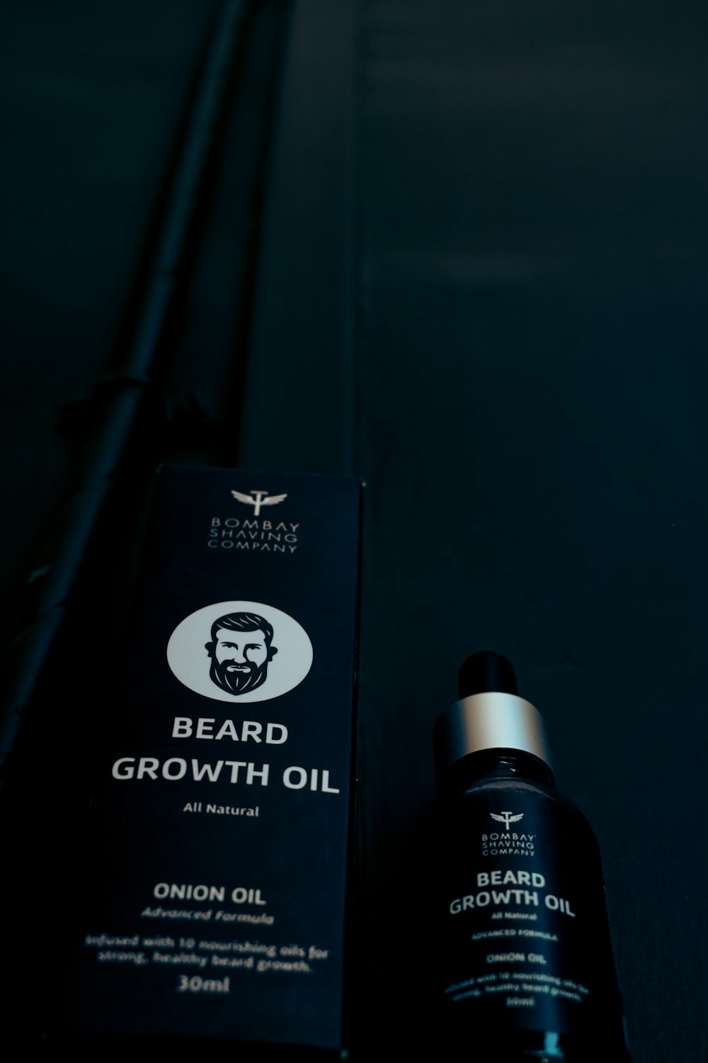 a bottle of beard growth oil next to a box