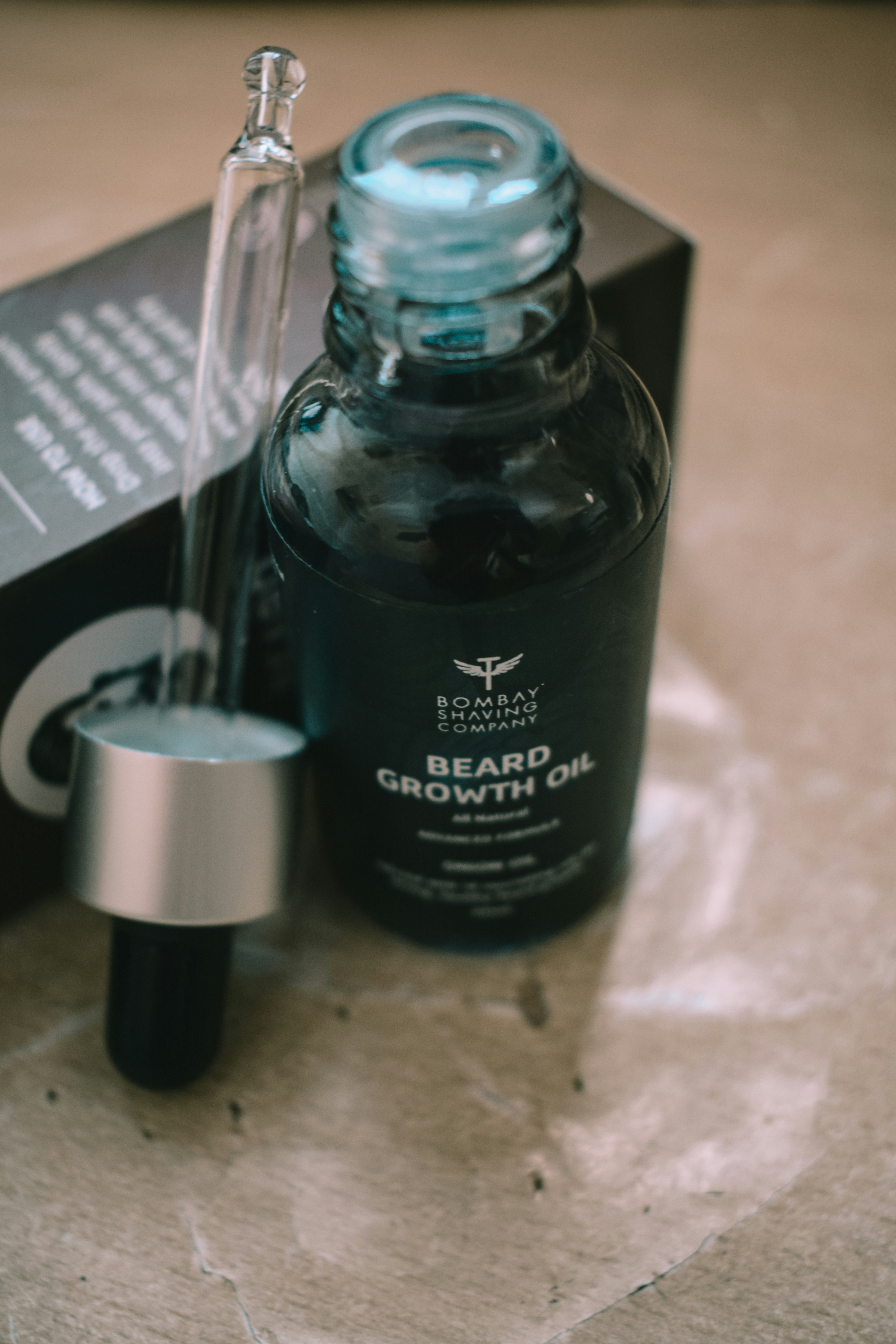 a bottle of beard growth oil next to a box