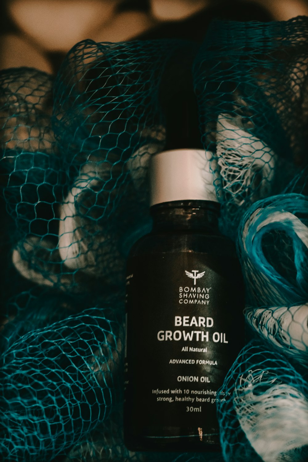 a bottle of beard growth oil sitting on top of a net