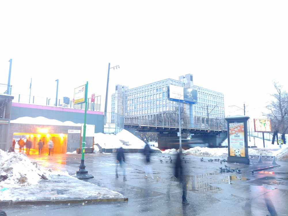 a group of people walking across a snow covered street