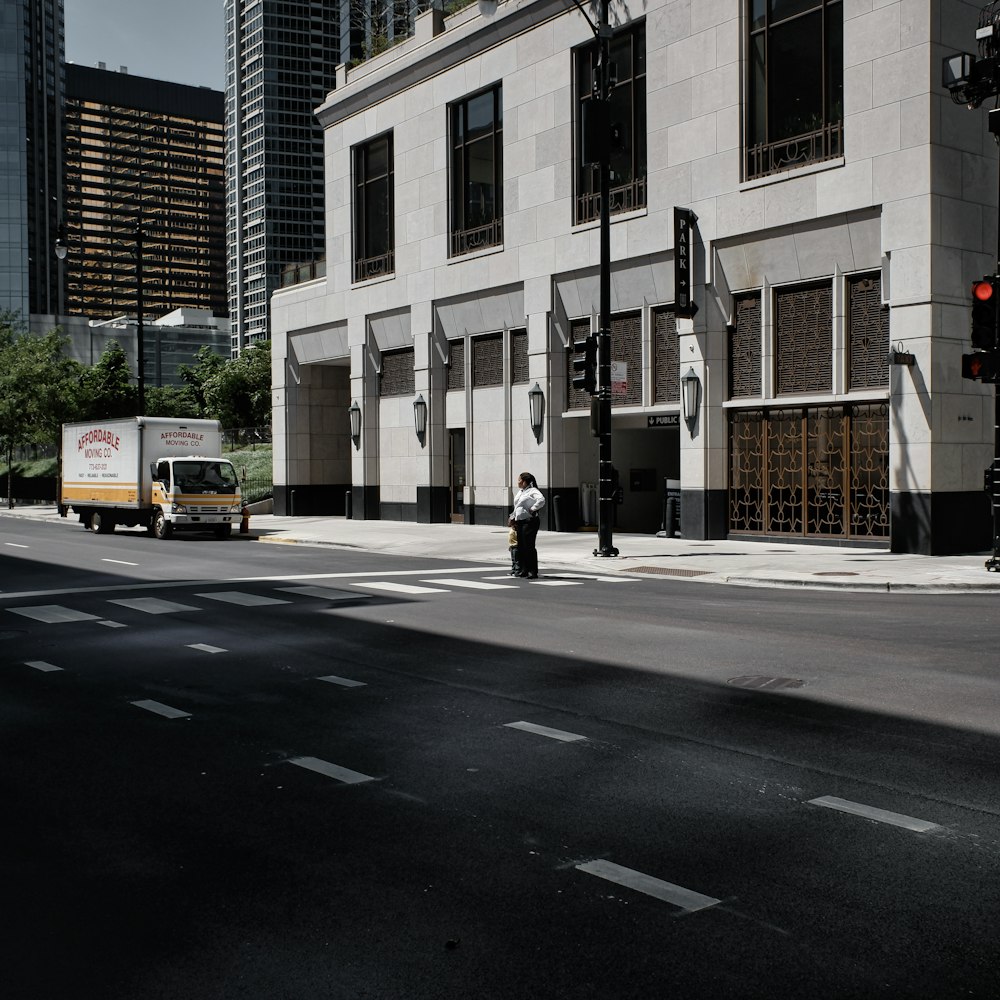 a man standing on the side of a street next to a traffic light