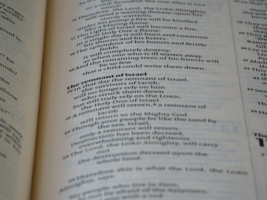 A close-up view of the pages of a book, featuring printed text in English. The text is organized into paragraphs with distinct headings, and the layout resembles that of a religious or reference book. The pages are a light cream color with dark, clear typography.