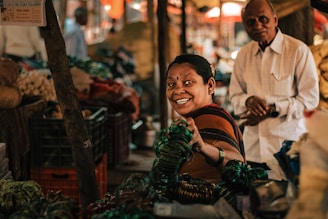 A vendor in Bangalore interacting warmly with a customer, surrounded by colorful merchandise.