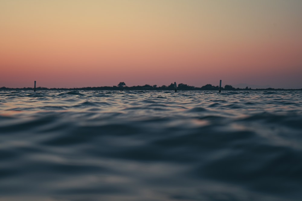 a body of water with a sunset in the background