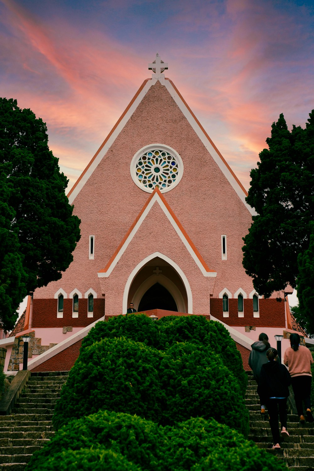 a church with a steeple and a stained glass window