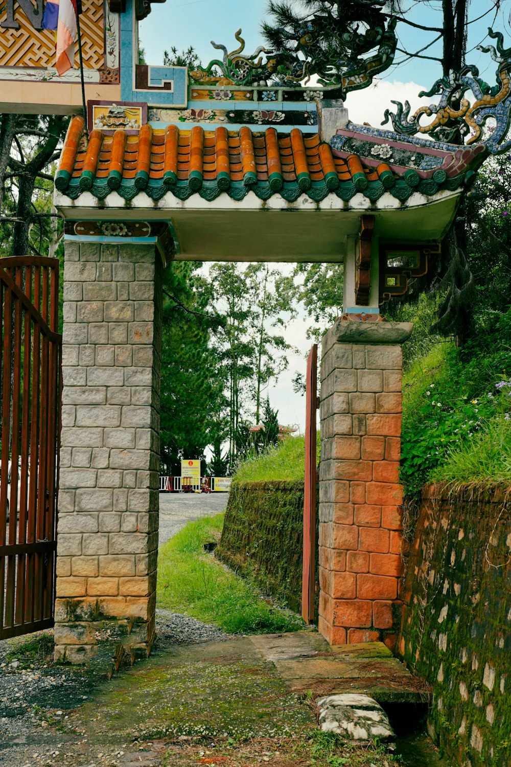 a gate with a brick wall and a green roof