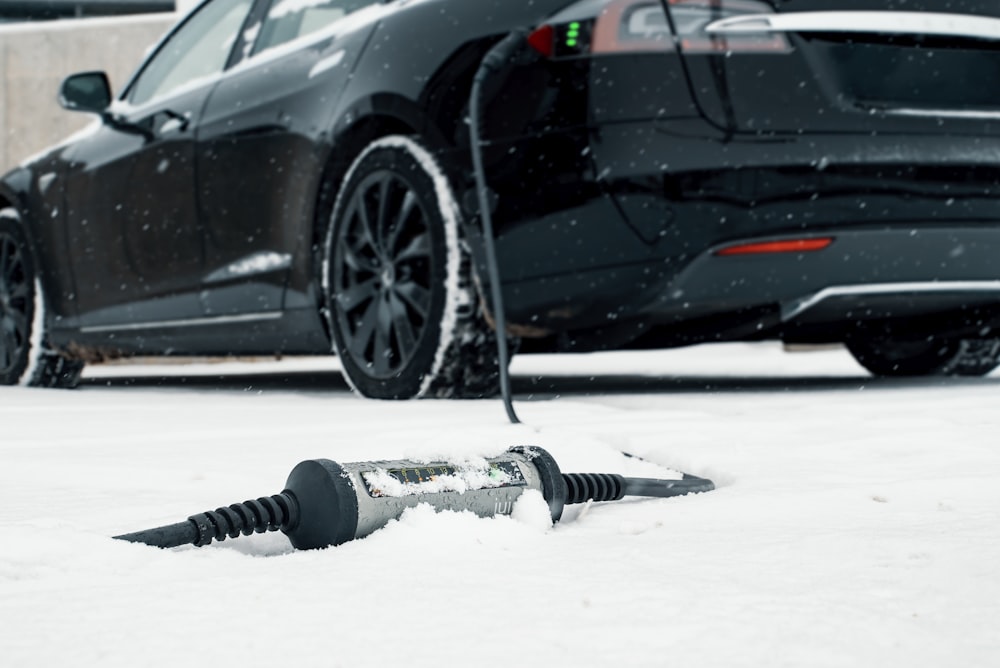 a car is parked in the snow next to a screwdriver