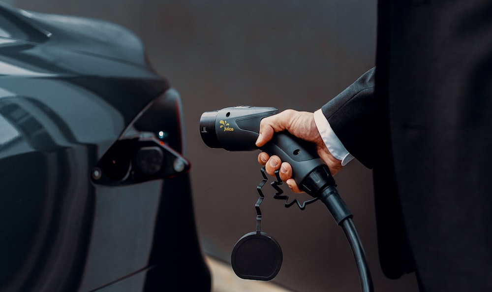 Ein Mann im Anzug pumpt Benzin in ein Auto