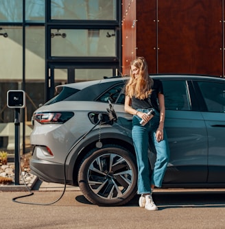 a woman standing next to a blue car