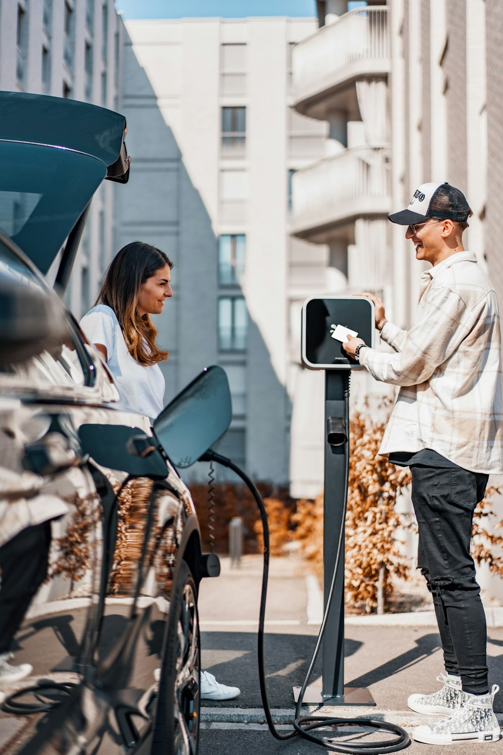 a man and a woman are charging their cars