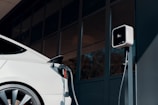 a white car plugged in to a charging station