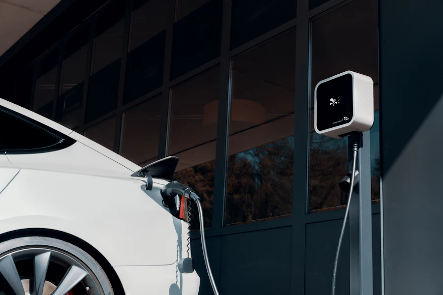 A car parked on a residential driveway with a charging cable plugged in