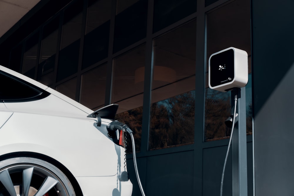 a white car plugged in to a charging station