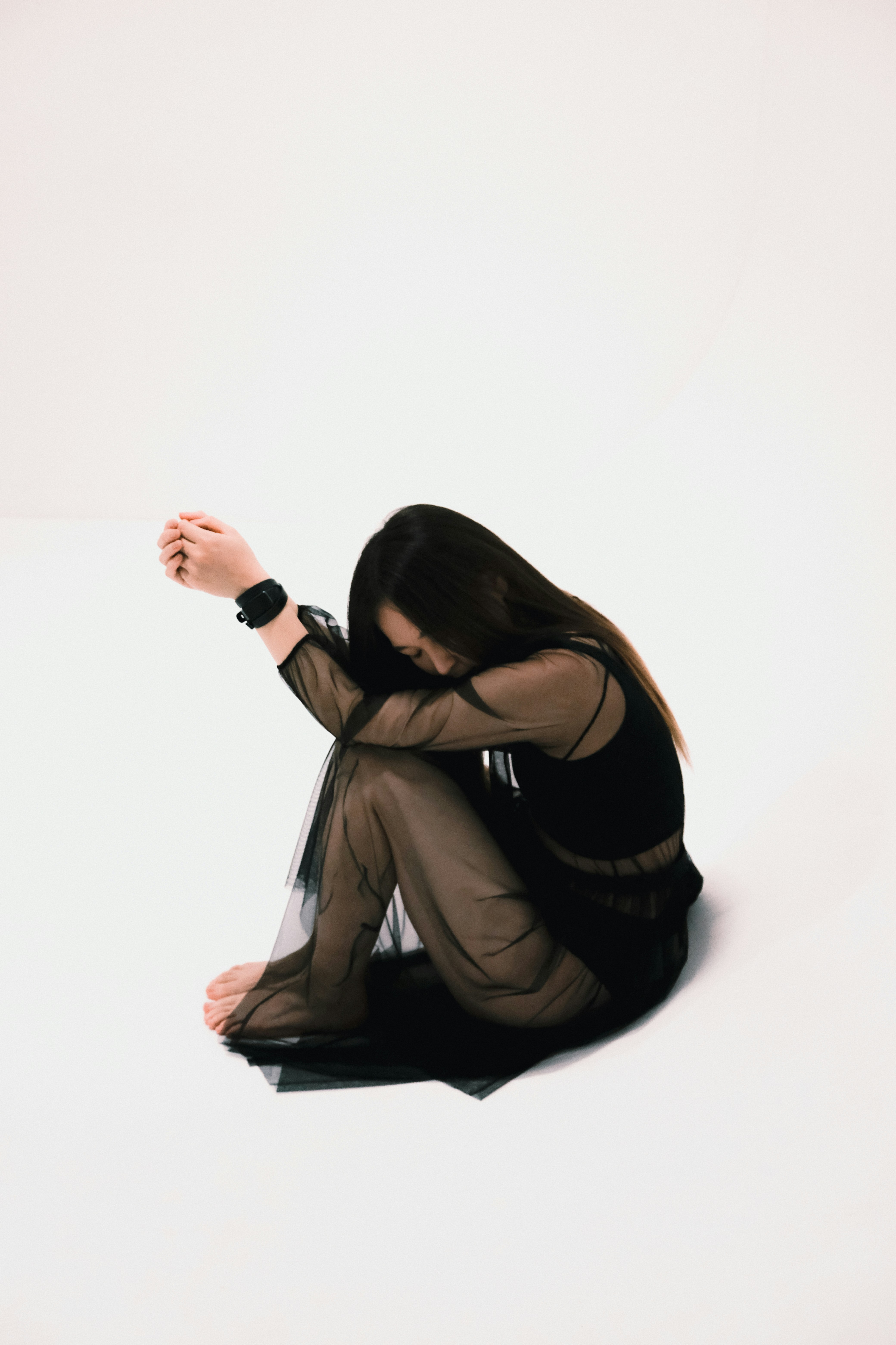 a woman sitting on the ground in a black dress