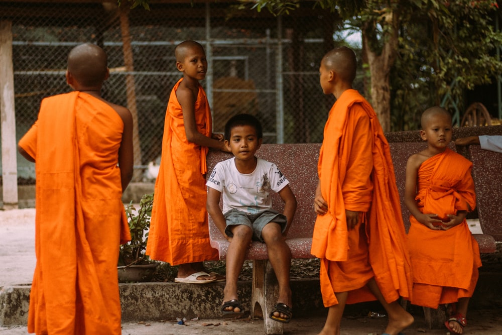 a group of young monks sitting on a bench