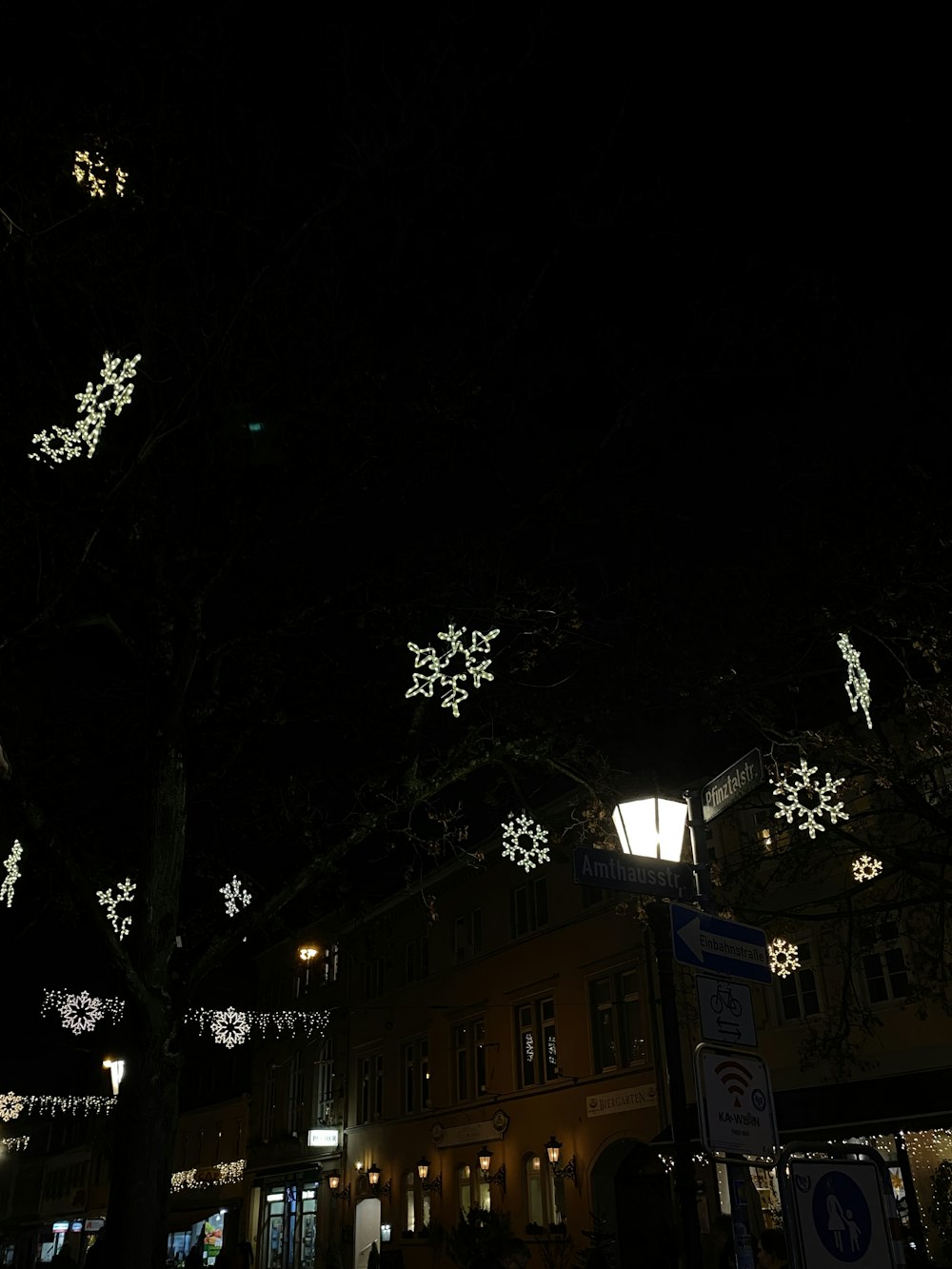 a street with a lot of snowflakes hanging from the trees