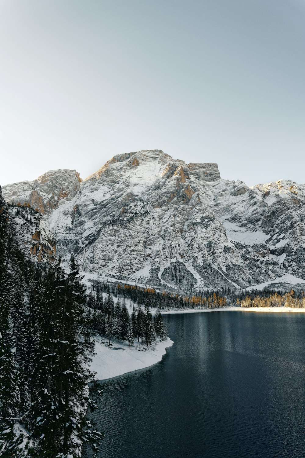 a lake surrounded by snow covered mountains