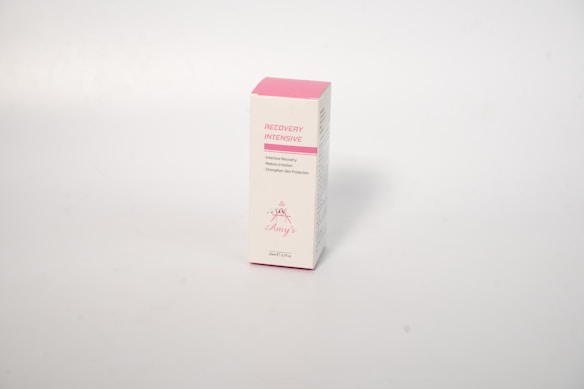 A rectangular white product box with pink accents. The box is labeled 'Recovery Intensive' and suggests purposes such as reducing irritation and strengthening skin protection.