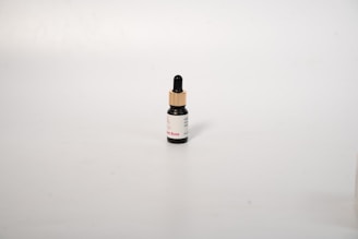 Close-up of a small bottle of mounjax weight loss drops with natural ingredients around it.