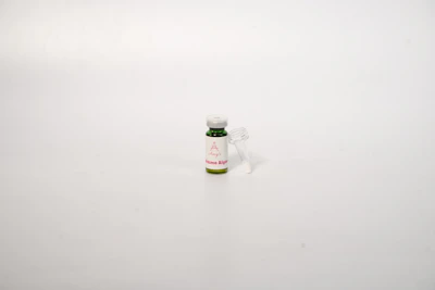 A clear bottle of liquid gargle with droplets on the surface