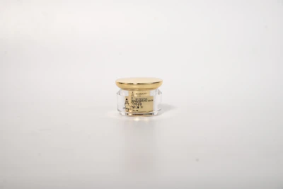 Elegant night cream jar with soft green and gold details on a clean white surface.