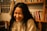 A smiling person sitting in a cozy therapy room.