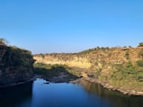 A serene view of the Snake River winding through Idaho's rugged mountains under a clear blue sky.