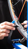 Close-up of a manual wheelchair wheel being adjusted with precision tools.