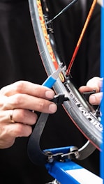 Close-up of a technician fixing a tyre puncture with tools.
