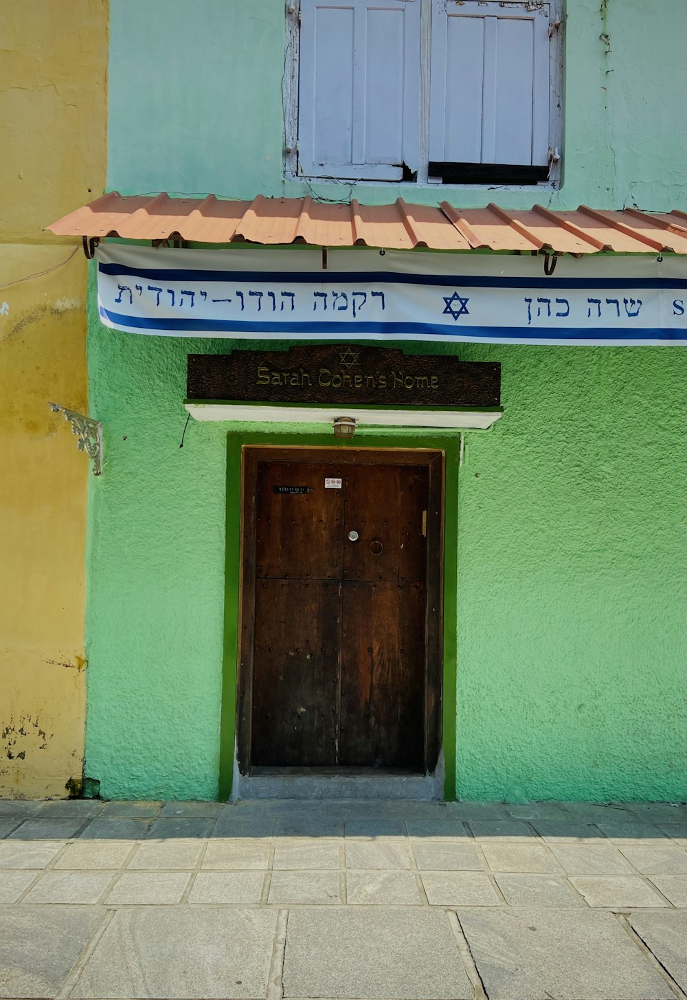 a green and yellow building with a door