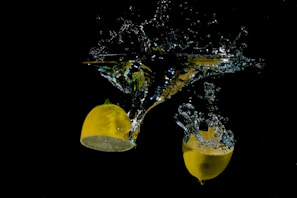 Splash of lemon juice captured mid-air over a clean white surface.