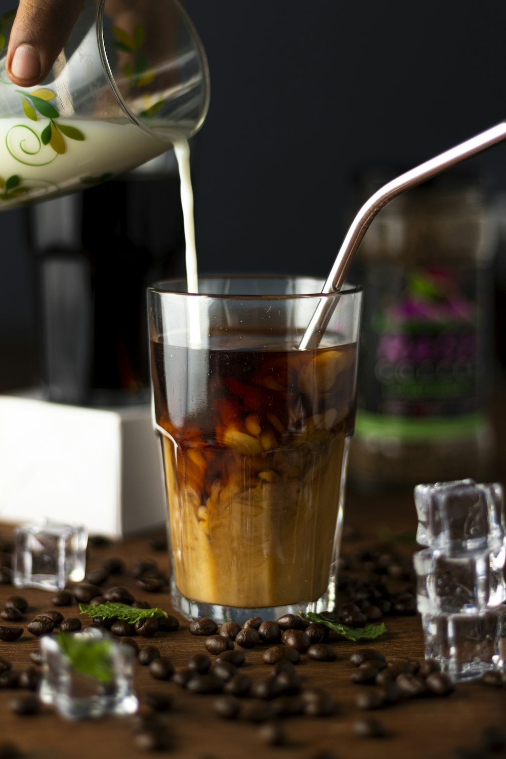 a person pouring a drink into a glass