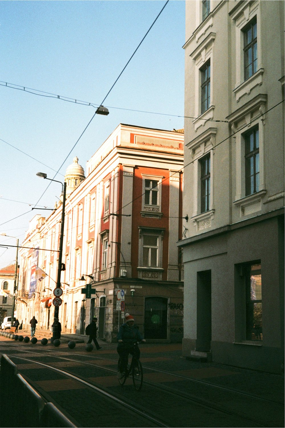 a man riding a bike down a street next to tall buildings