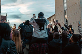 a group of people taking pictures with their cell phones