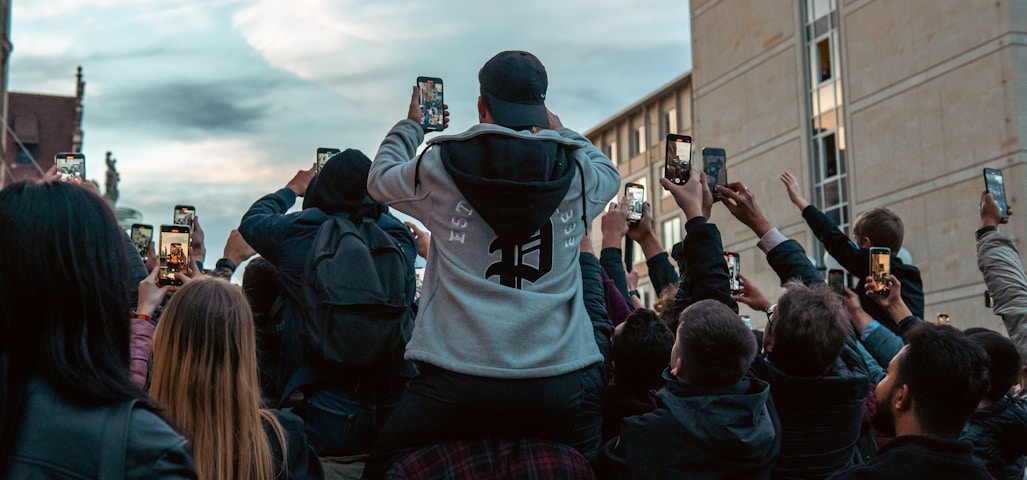 a group of people taking pictures with their cell phones