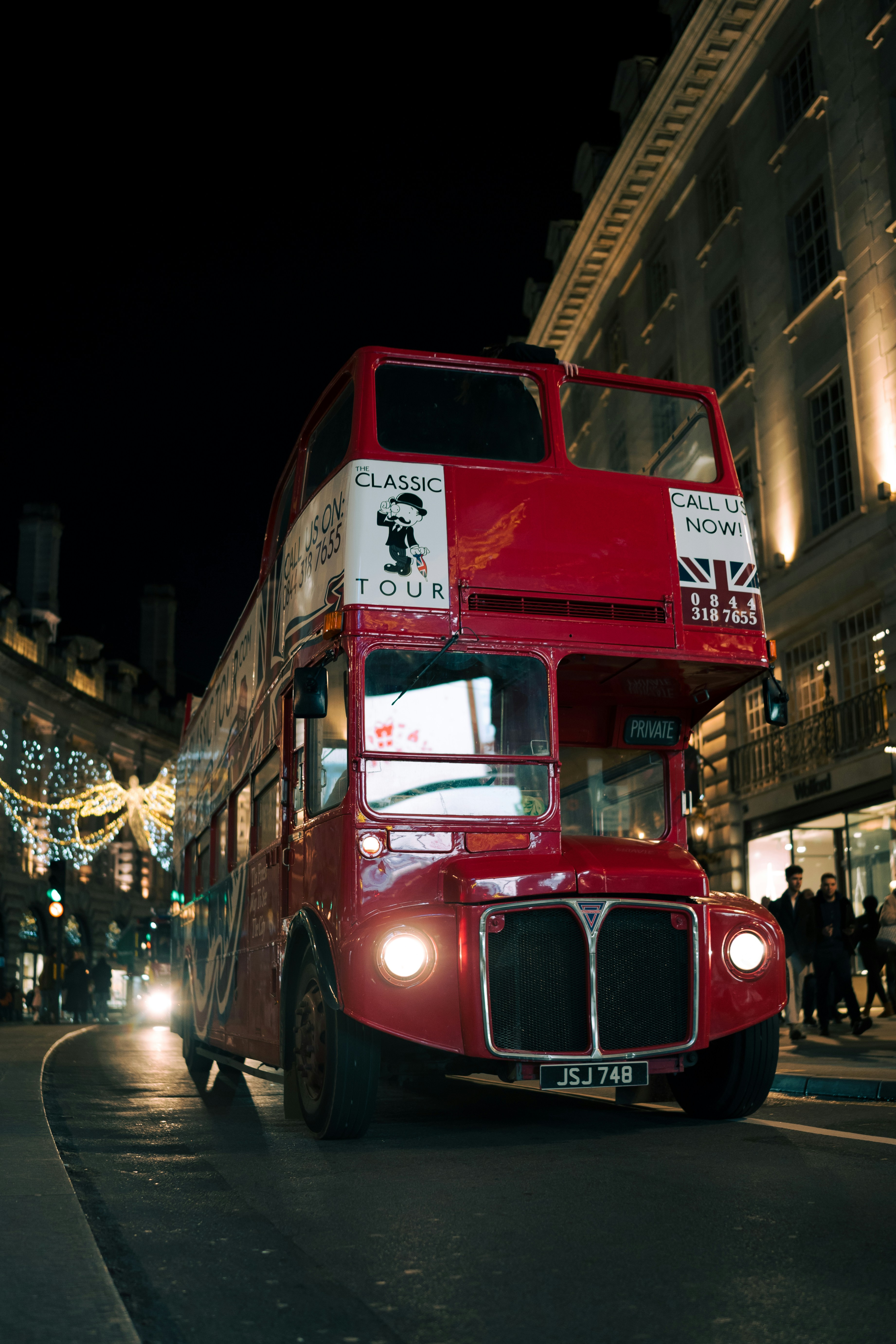 a red double decker bus driving down a street
