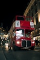 a red double decker bus driving down a street