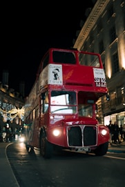 a red double decker bus driving down a street