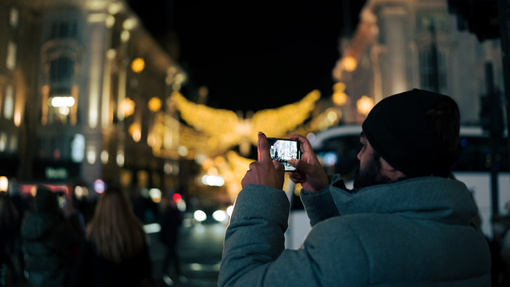 a man taking a picture of a building at night