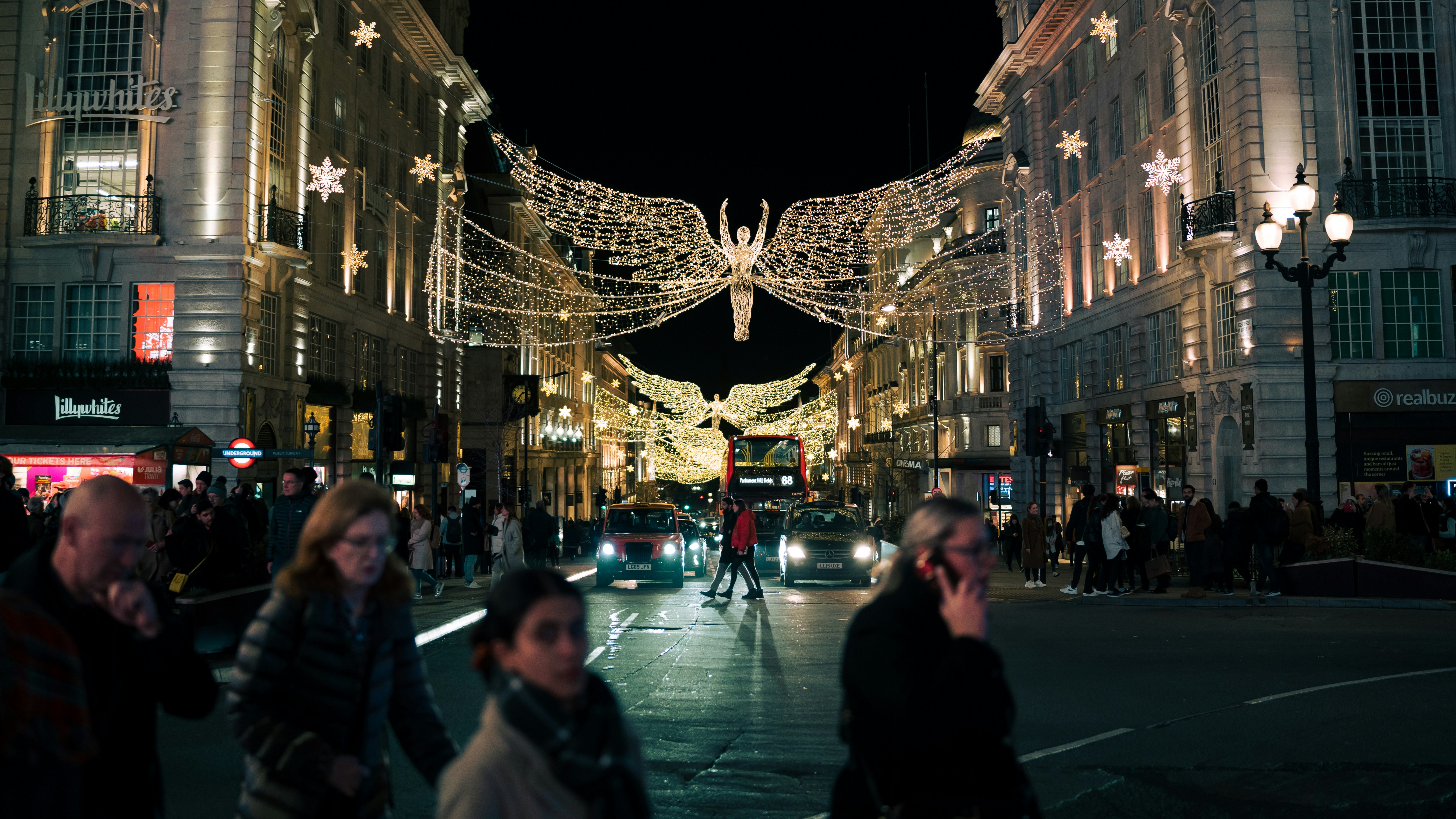 people walking down a city street at night