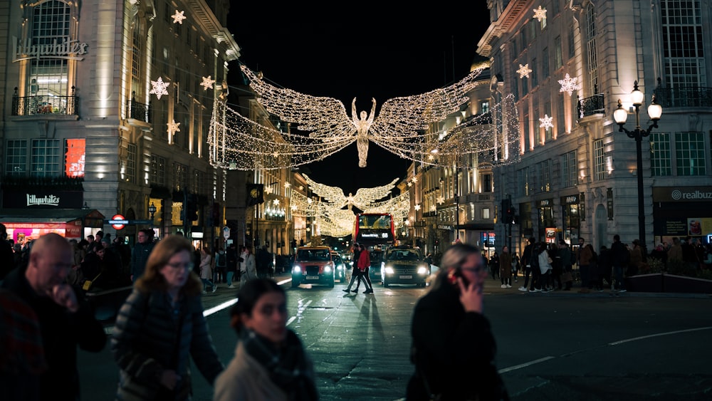 people walking down a city street at night