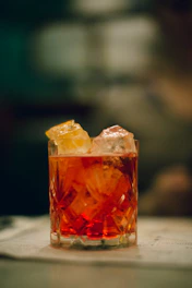 Close-up of a crystal glass filled with a vibrant, artfully garnished cocktail.