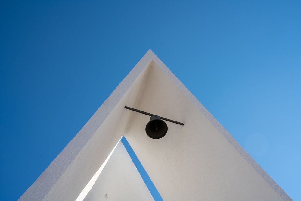 une horloge sur le côté d’un bâtiment avec un ciel bleu en arrière-plan