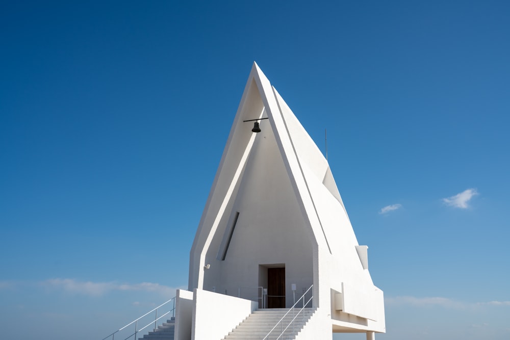a white church with a steeple and stairs leading up to it